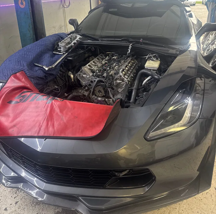 Gray Corvette in the bay with engine components exposed