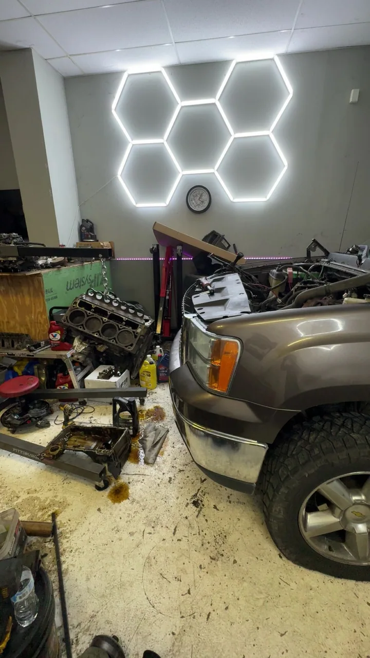 Pickup truck in the shop beside an engine hoist