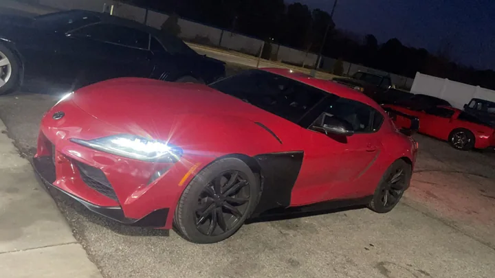 Red Toyota Supra outside the shop in the evening