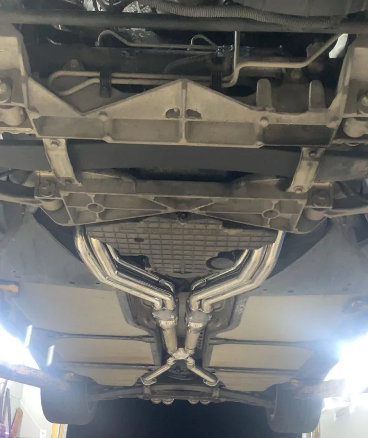 Underside of a raised vehicle showing exhaust pipe routing